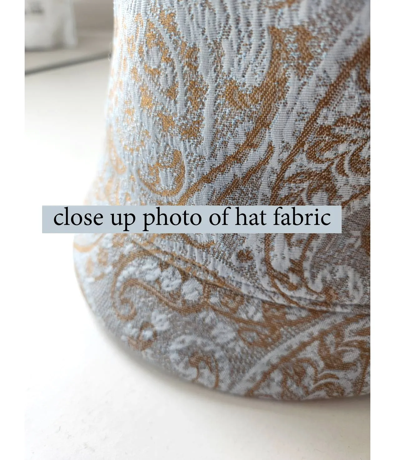 Light blue and brown cloche hat with multicolored art deco print ribbon