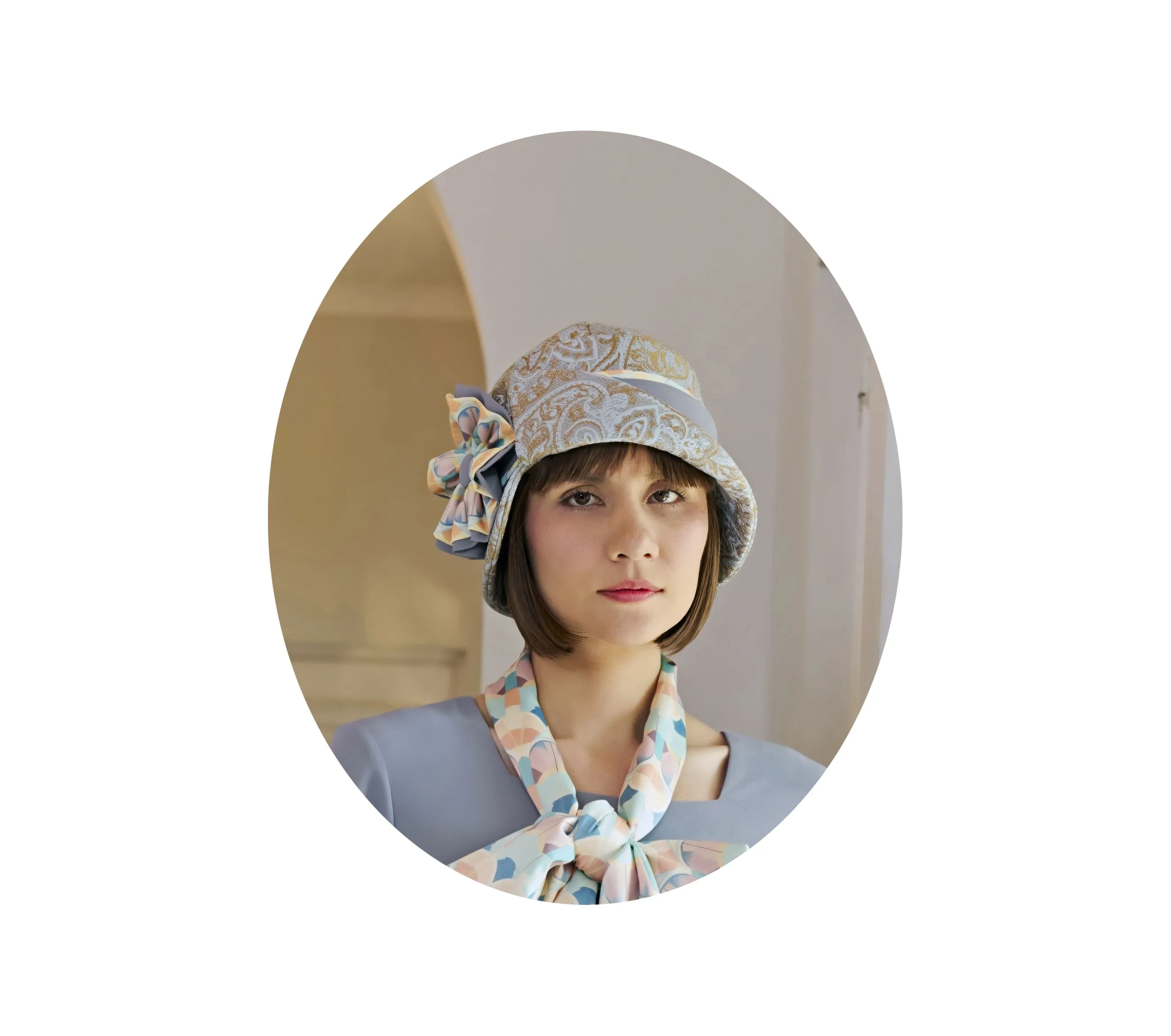 Light blue and brown cloche hat with multicolored art deco print ribbon