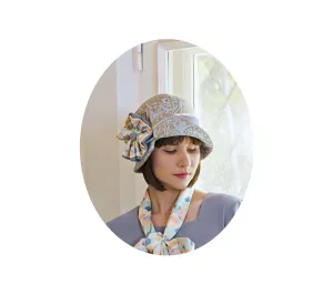 Light blue and brown cloche hat with multicolored art deco print ribbon