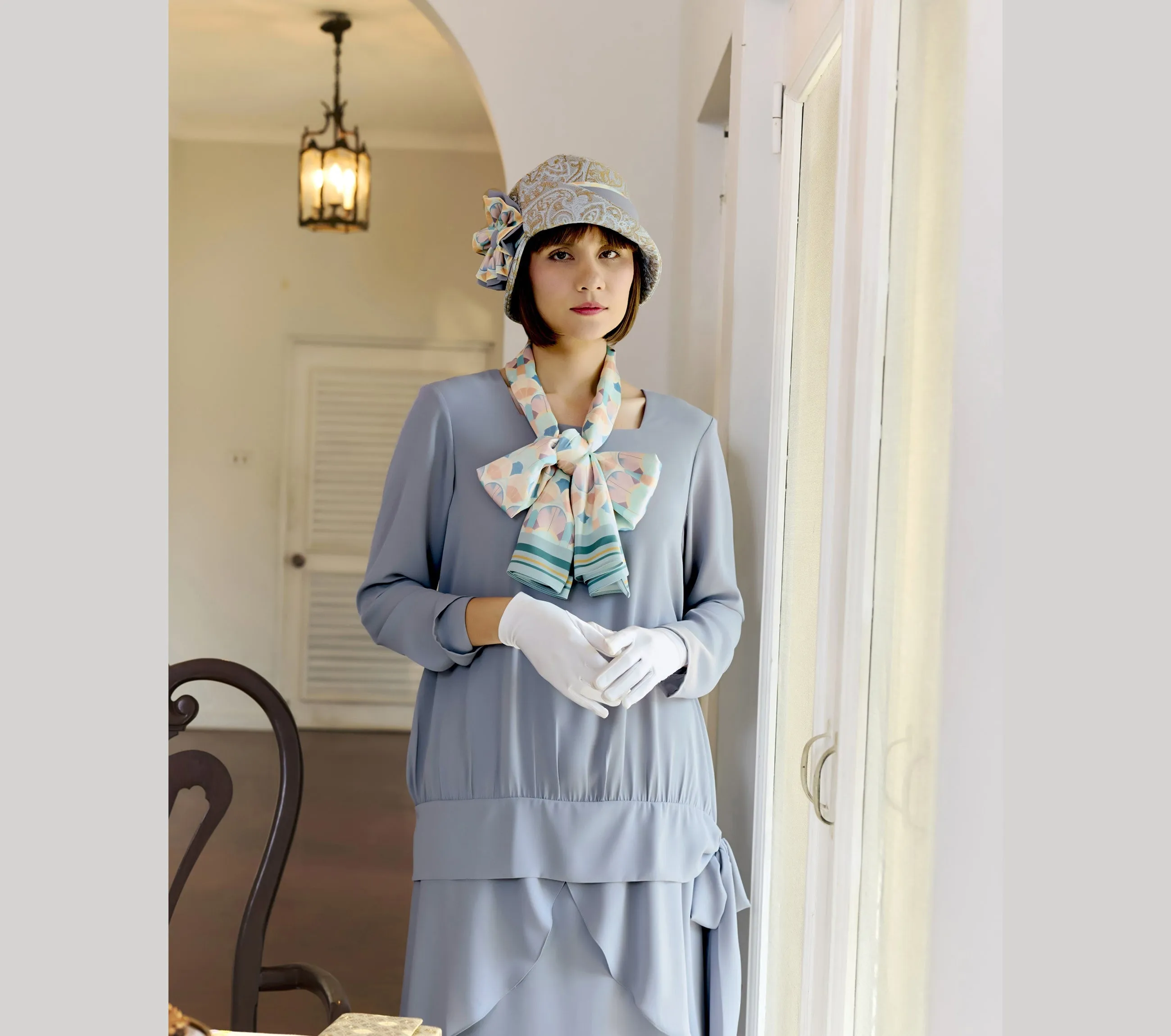 Light blue and brown cloche hat with multicolored art deco print ribbon