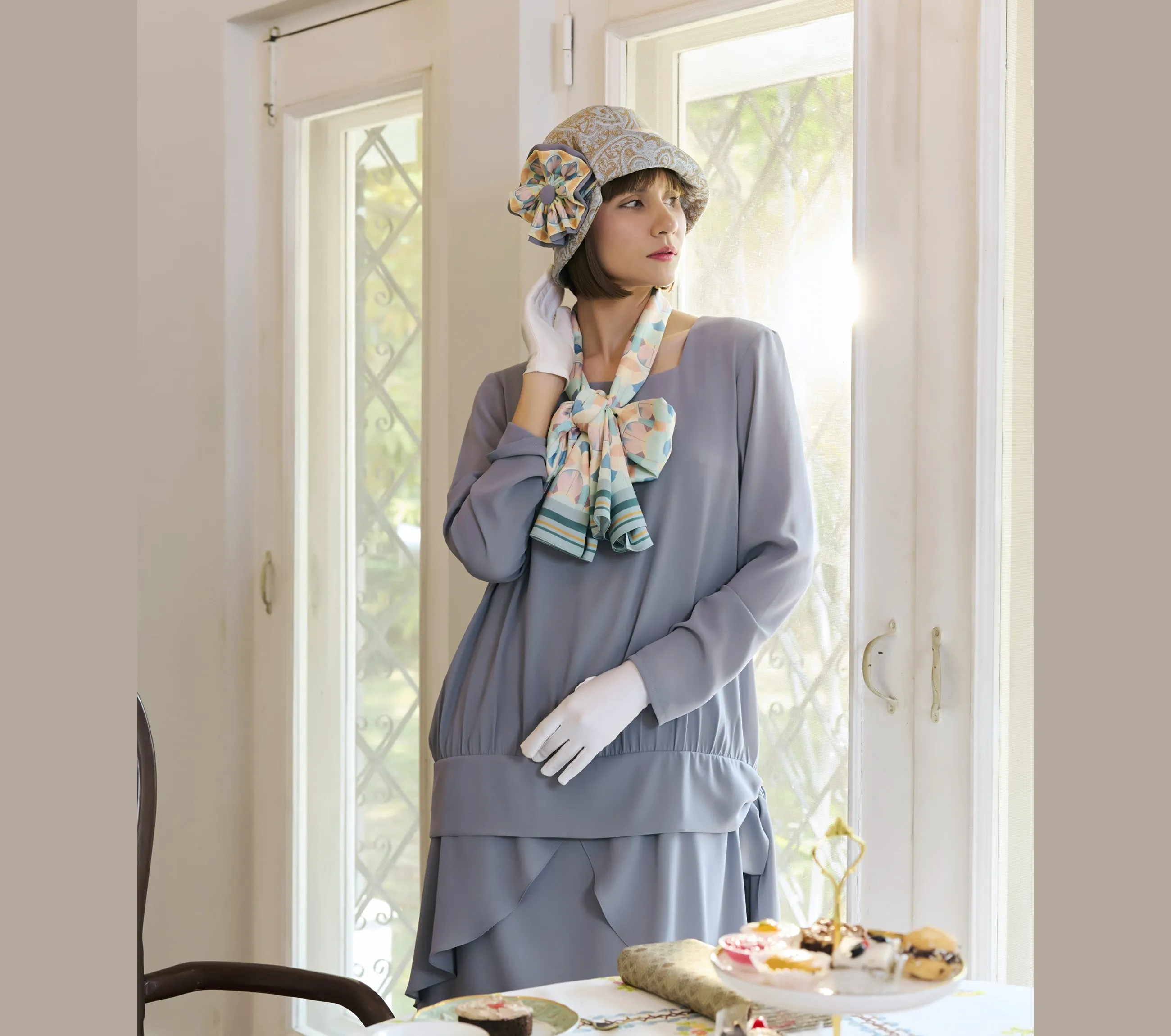 Light blue and brown cloche hat with multicolored art deco print ribbon